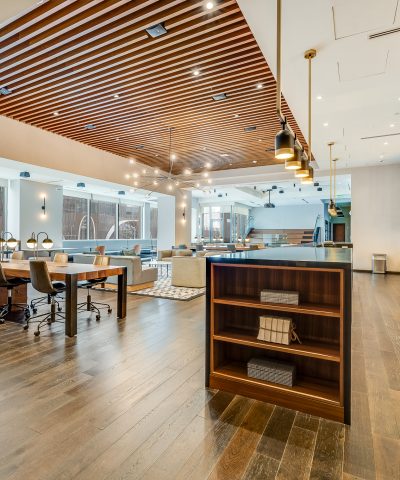 Open lounge and meeting area at Echelon Innovation Center, with a slatted wood ceiling and hardwood floors